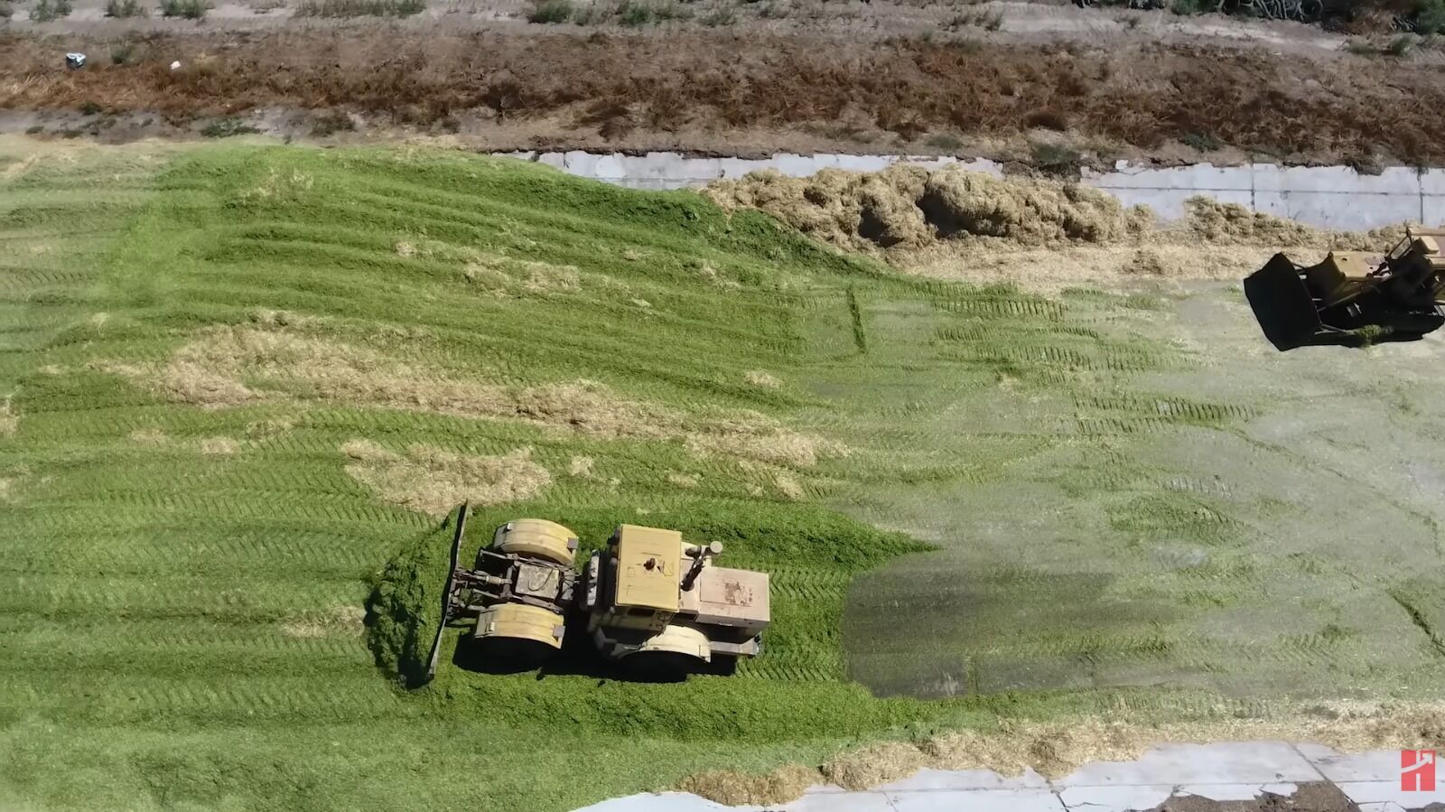 Máquina agrícola em campo de pastagem verde